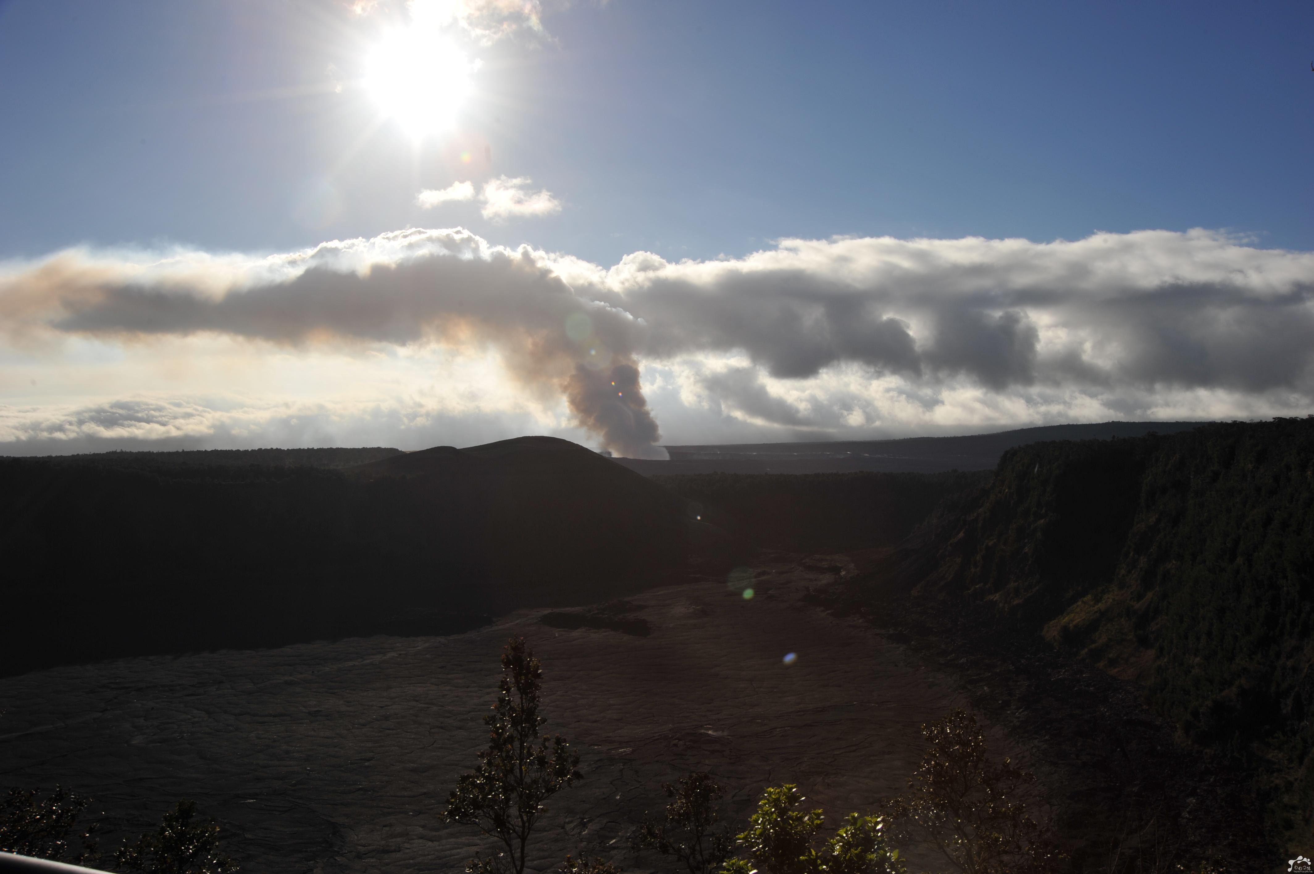 Sunlight breaking through clouds above a rocky landscape