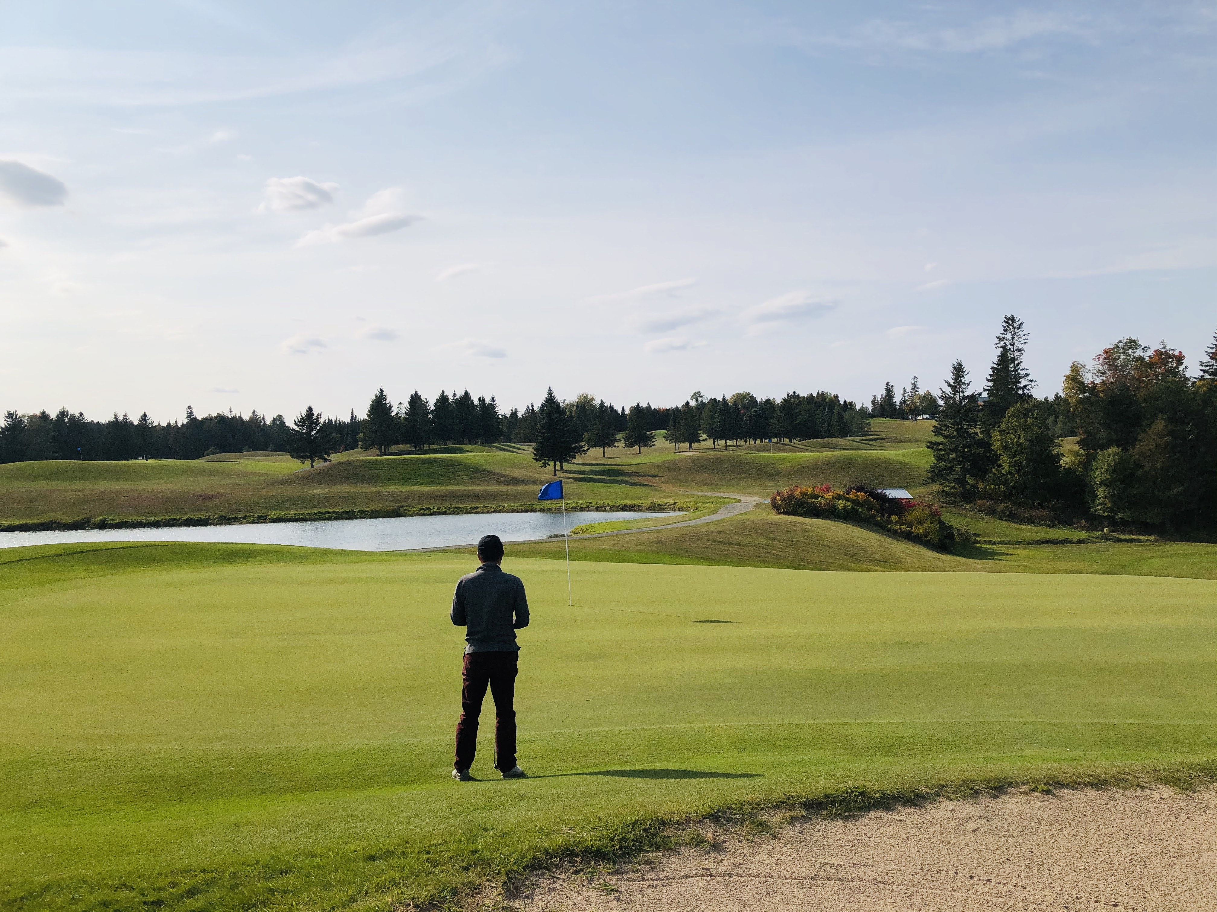 Golfer standing beside a putting green