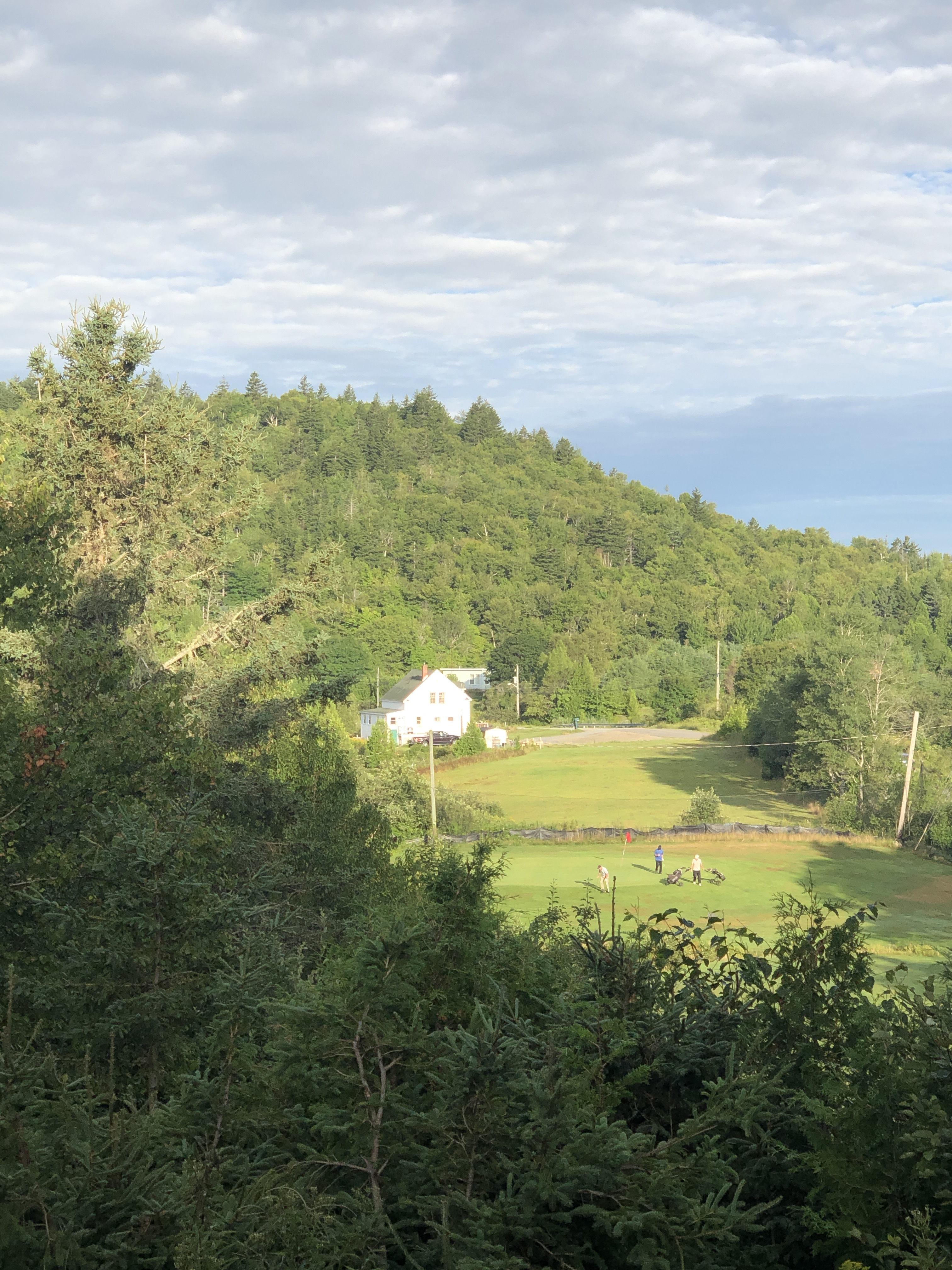 Tree-covered hills and a golf fairway