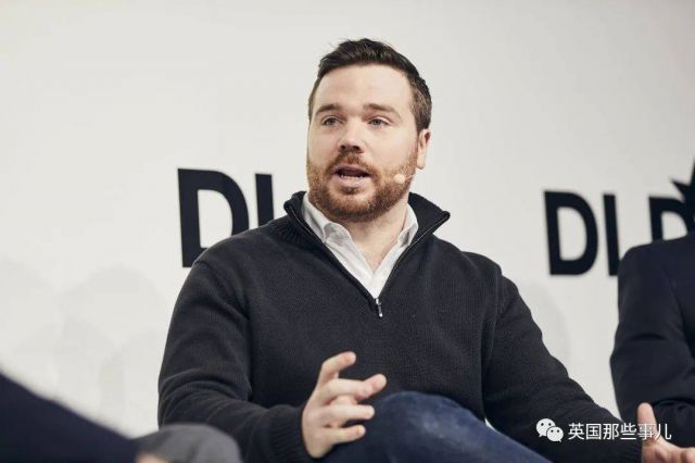 Man speaking at an event with a microphone clipped to his shirt