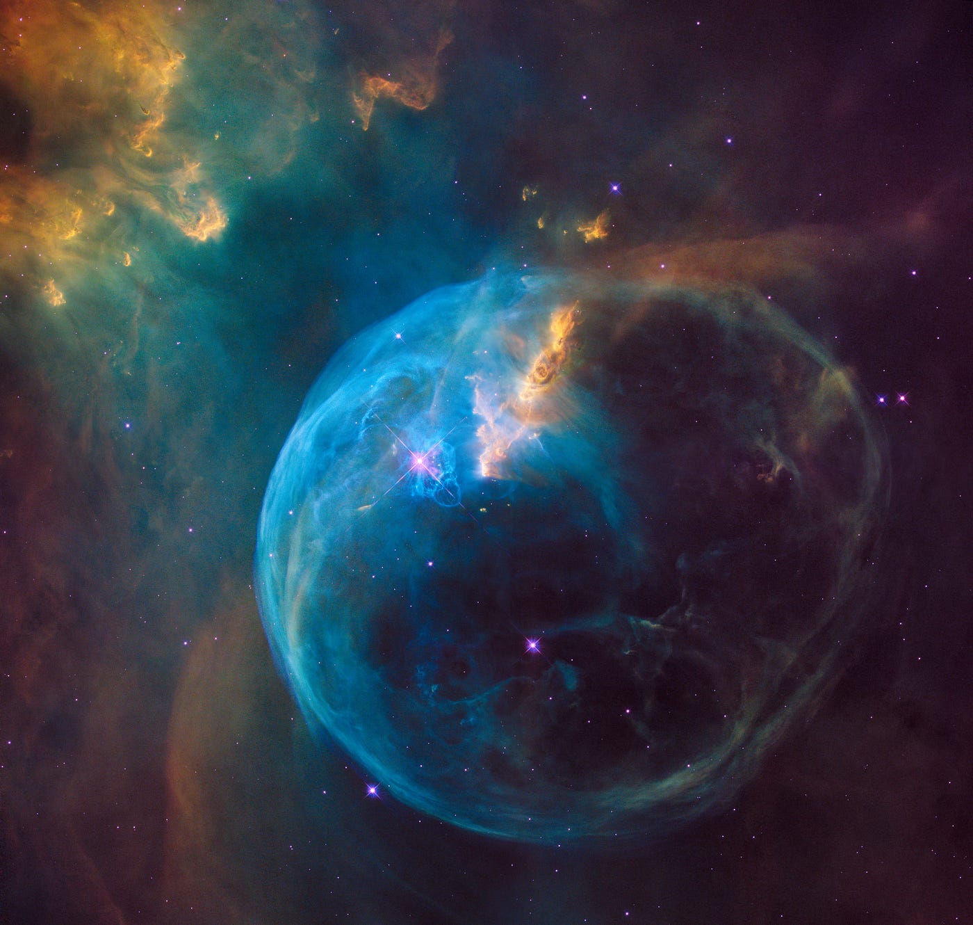 Astronomical image of a blue and pink nebula surrounded by stars