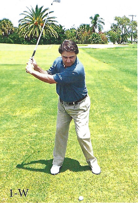 Golfer demonstrating an L-shaped arm and club position during the backswing
