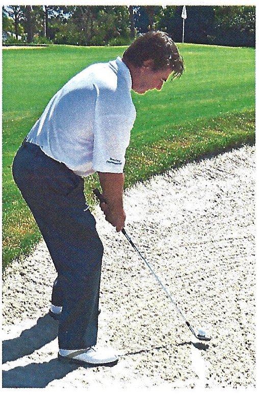 Side view of a golfer setting up for a greenside bunker shot