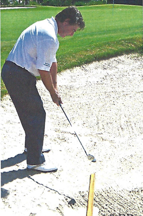 Golfer demonstrating the swing path for a bunker shot