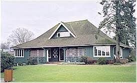 Small clubhouse surrounded by lawn and trees
